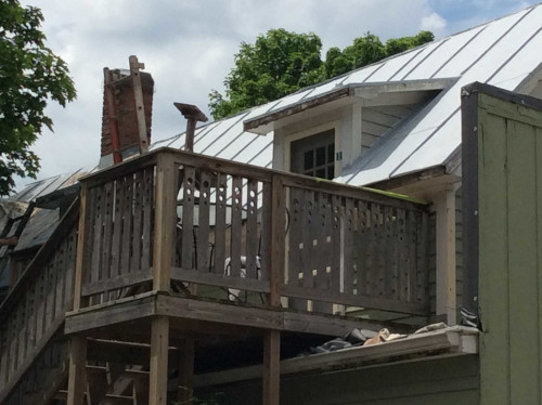 A close-up shot of Design Ranch's roof with a fresh coat of primer in the sunlight.