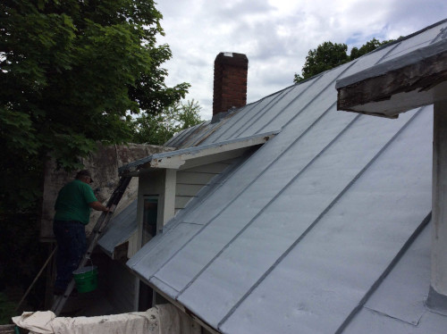 A photo showing a section of freshly primed roof, and Scott working down the line.